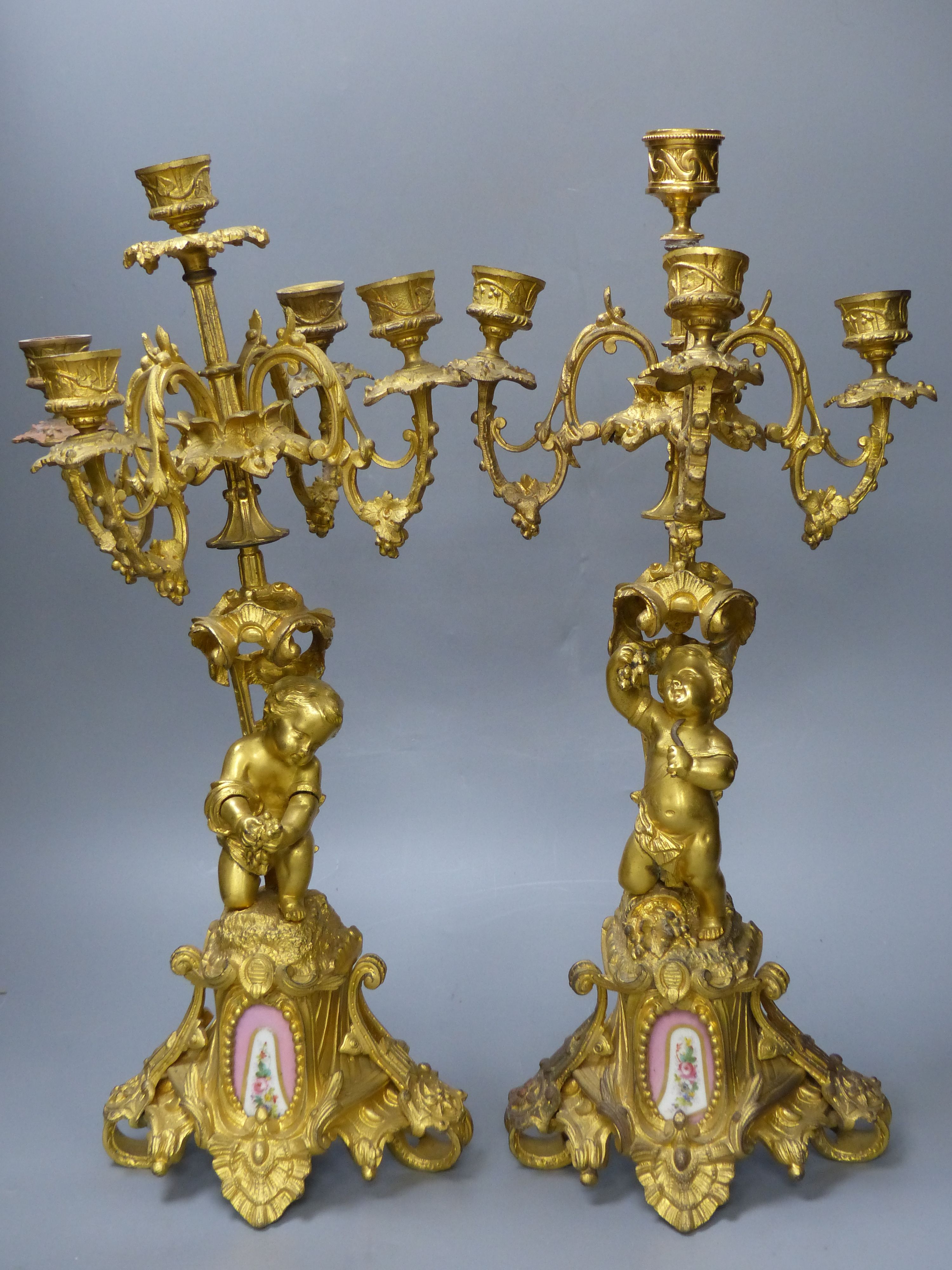A pair of 19th century French ormolu cherub candelabra, with porcelain plaques to base, height 47.5cm